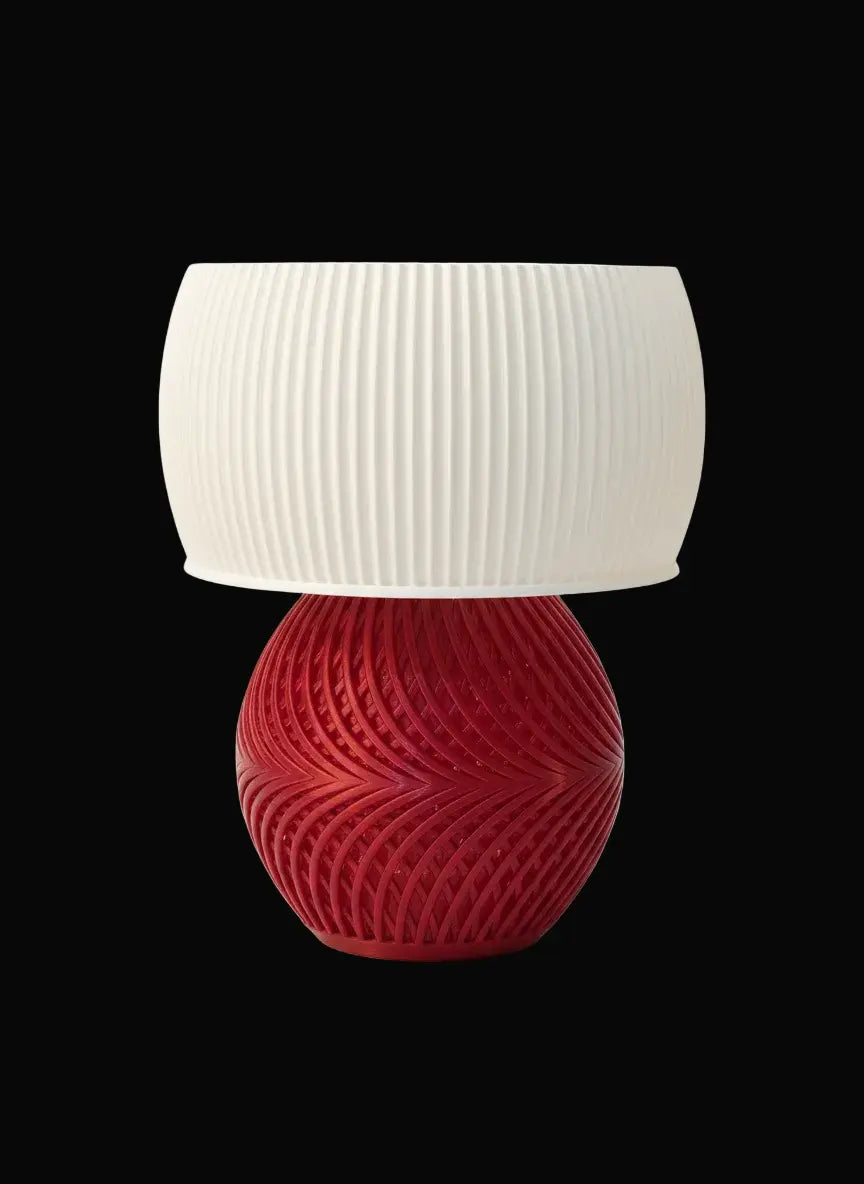 Table lamp with a red base and white shade on a white background
